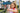 Young girl with a red backpack smiling at school